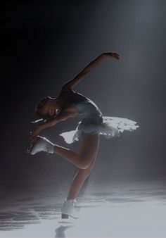 a ballerina is performing in the dark