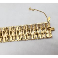 Goldtone articulated bracelet with fold over clasp and security chain. Marked "Monet." Measures:  7 3/8 inches long by 1 1/4 inches wide. Condition: Very good, minor wear to the bar the fold over clasp attaches to. From Monet's 1972 Fanchette line.  A necklace matching this bracelet is shown on pg. 222 of Alice Vega's book "Monet; the Master Jewelers." Vintage Formal Chain Bracelet With Box Clasp, Vintage Link Bracelet With Clasp, Vintage Gold Link Bracelet, Metal Chain Bracelet With Clasp For Formal Occasions, Formal Metal Chain Bracelet With Clasp, Vintage Link Bracelet, Necklace Matching, Wide Bracelet, The Fold