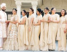 a group of women standing next to each other in front of a building with white pillars