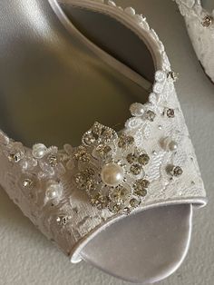 Gorgeous and comfortable Lace shoes heel is 2 1/2'' inches VERY ELEGANT AND MODERN color: Diamond white = Off-white, and also available in IVORY LACE floral trim edging the shoes, silver dots all over and a few scattered glass crystals and pearls over the front. US Sizes: M width (standard width) (I'm sold out of some sizes please look at sizes menu) US Sizes: 5, 5.5, 6, 6.5, 7, 8, 8.5, 9, 9.5, 10, 11 Outside USA, please goggle a US Size chart convertor before ordering or contact for help. FINAL White Embellished Wedding Shoes For Formal Occasion, White Embellished Wedding Shoes, Formal White Embellished Wedding Shoes, Elegant White Wedding Shoes With Rhinestones, White Low Heel Wedding Shoes With Rhinestones, Elegant White Embellished Wedding Shoes, White Open Toe Wedding Shoes With Rhinestones, White Embellished Shoe Clips For Formal Occasions, White Low Heel Heels With Rhinestones