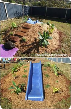 a blue slide in the middle of a yard next to a flower bed and trees