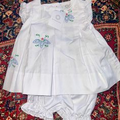 For Sale: Proper Peony White Cotton Swing Set (12mo) Elegance Meets Charm! This New-With-Tags Swing Set Features Delicate Blue And Red Floral Embroidery On White Cotton. Complete With A Matching White Ruffled Bloomer, It's A Timeless Ensemble For Your Little One. Dress Them In Sophistication With The Proper Peony's Exquisite Craftsmanship. Spring Cotton Sets With Embroidered Hem, White Cotton Sets With Embroidered Hem, Summer Cotton Sets With Embroidered Hem, White Ruffled Cotton Sets, White Cotton Ruffled Sets, White Cotton Sets With Ruffles, Fitted Embroidered Sets For Baptism, Embroidered Cotton Sets For Baptism, Cotton Embroidered Sets For Baptism