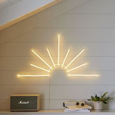 a white fireplace with a sunburst light above it and a radio next to it