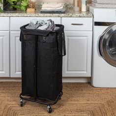 a laundry hamper sitting in front of a washer next to a dryer