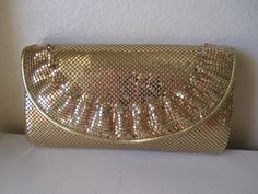 This is a wonderful 1970s gold Whiting & Davis evening clutch. The only evening bag you'll ever need!  It goes with everything. This one has a classy little ruffle along the edge, A great piece! Measures 8.5 inches by 5 inches. Large enough for you cell phone. There is one zippered pocket inside. In original box and with original tag. Wear it as a clutch or attach the 42 inch gold leather strap to wear as a shoulder bag. In minty vintage condition! Gold Vintage Clutch For Events, Gold Vintage Clutch For Party, Vintage Gold Party Clutch, Chic Gold Clutch For Dinner, Elegant Gold Evening Bag For Dinner, Vero Beach Fl, Foldover Clutch, Vero Beach, Evening Clutch