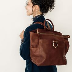 Natasha is the bag for the woman that does it all. This bag seamlessly moves from work bag, to mom bag, to travel bag. You can carry it as a backpack, or purchase one of our bag straps to make it a crossbody/shoulder bag. It can also be used with our stroller straps for extra momming functionality. Natasha has the perfect blend of style and organization to get you through all of life's big, and small, moments. Features Convertible: Wear it as a backpack or by the top handle, or upgrade with a cr Mom Bag, Season Of Life, Laptop Travel Bag, Stroller Straps, Mom Bags, Raw Leather, Handbag Stores, Convertible Backpack, Small Moments