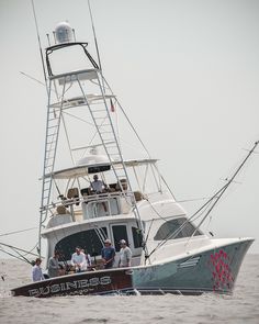 a group of people riding on the back of a boat in the middle of the ocean