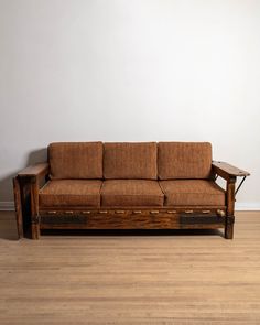 a wooden couch sitting on top of a hard wood floor