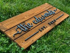 a wooden sign sitting in the grass