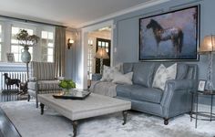 a living room filled with furniture and a painting on the wall