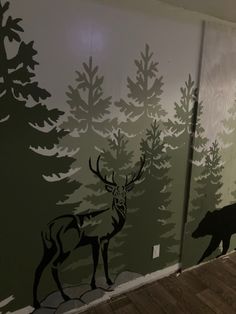 the wall is painted with deer and pine trees