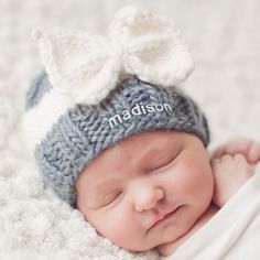 a newborn baby is wearing a knitted hat with a bow on it's head