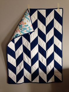 a blue and white quilt hanging on a wall