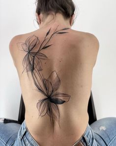 the back of a woman's body with flowers on her upper and lower back