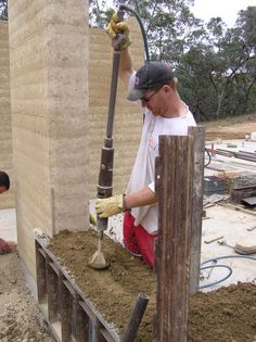 two men are working on the foundation of a building with cement and concrete mortars