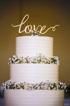 a wedding cake with the word love spelled on top