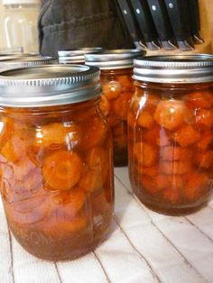 three jars filled with pickles sitting on top of a table