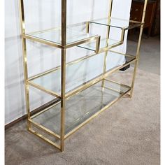 a glass and brass shelf on carpeted floor