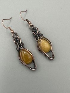 Gorgeous yellow earrings wrapped in swirly oxidized copper wire. Earrings are 2.25 inches long and .5 inches wide. Comes with nickel free french wire hooks. Handmade Yellow Copper Jewelry, Copper Wire Earrings, Wired Jewelry, Wire Earrings Handmade, Wire Jewelry Earrings, Wire Wrapped Stone Jewelry, Wire Wrapped Jewelry Diy, Weaving Ideas, Wire Jewelry Designs