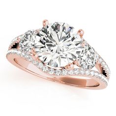 a three stone engagement ring with two side stones on the band and an oval diamond center