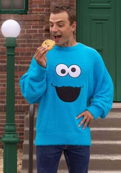 a man eating a cookie while standing next to a street light and lamp post in front of a brick building