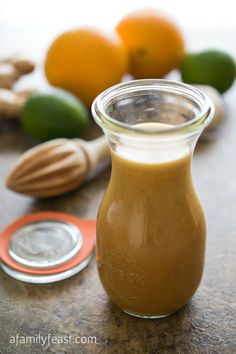 a glass jar filled with peanut butter sitting on top of a table next to some vegetables