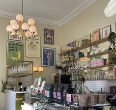 there are many pictures on the wall above the counter in this shop, and one is hanging from the ceiling