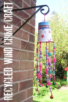 a colorful wind chime hanging from the side of a brick building