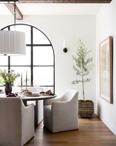 the dining room table is set with two chairs and a potted plant in front of it