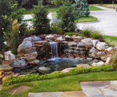 a small waterfall in the middle of a garden