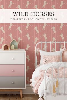 a white bed sitting next to a pink wallpaper covered in little fairy silhouettes