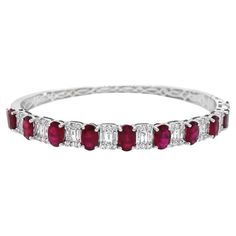 This 18k white gold bangle features 4.49 carats of rubies and emerald-cut diamonds composed of baguette and round diamonds. It is secured with a box clasp and figure-8 safety closures. This bangle is designed to be worn individually or combined with other bracelets for a layered look. Ruby - 4.49 Cts Diamond- 1.02 Cts All Diamonds are G-H/SI Ruby And Diamond Bracelet, Luxury Red Baguette Diamond Jewelry, Red Baguette Cut Jewelry With Baguette Diamonds, Red Baguette Cut Diamond Jewelry, Modern Bangle, White Gold Bangle, Modern Bracelets, Diamond Bangles Bracelet, Cuff Bangle Bracelet