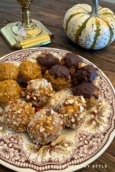 a plate filled with different types of desserts on top of a wooden table next to a gourmet pumpkin