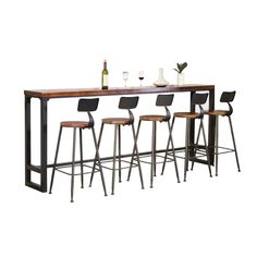 the bar table has four stools and is set up with wine glasses on it