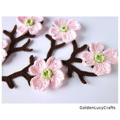 crocheted pink flowers with green centers on white background, set of four pieces