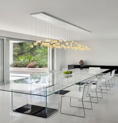 a modern dining room with glass table and white chairs