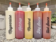 four different types of condiments are lined up in a row on the counter