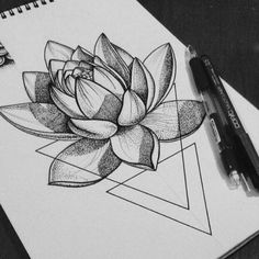 a drawing of a lotus flower with geometric shapes in the background and a pen resting on it