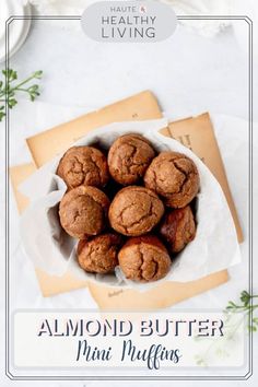 chocolate muffins in a white bowl on top of a table with envelopes