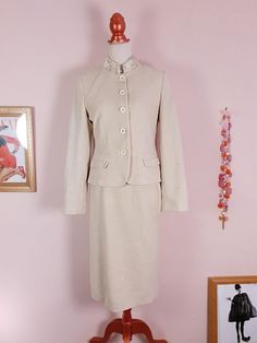 "This vintage 90s Laura Ashley suit pays homage to 60s style. Tailored from a luxuriously soft textured cotton/wool/nylon blend in a clotted cream hue, the jacket features a faux fur collar, shoulder pads, cream button front closure, two front flap pockets, decorative buttons on the cuffs and white floral patterned lining. The matching skirt features a back zip closure, cream satin lining and a gathered design at the back. Era - 1990s Brand - Laura Ashley Jacket fit - 21.5\" length / 34\" to 36\" Bust / 30\" to 32\" Waist / 24\" Sleeve length Skirt fit - 25.5\" length / 26\" to 27\" Waist / 35\" to 36\" Hips Fabric - cotton 60%, wool 28%, nylon 12% Label size 10 UK Care - Dry clean Excellent condition" Cream Suit, Vintage Laura Ashley, 60s Style, Clotted Cream, Prairie Dress, Skirt Fits, Decorative Buttons, 60s Fashion, Faux Fur Collar