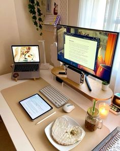 a desk with a laptop, monitor and keyboard on it