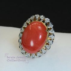 This pretty Levian red Coral Ring is set in 14k solid gold and is surrounded by a diamond halo!Ring Size: 5.75Total Weight: 8.45 gramsPrecious Metal: 14k solid goldPrecious stones:-Coral Center Stone: 19.3mm x 14.1mm, 10.1 carats-White Round diamonds: 0.2 ctHallmark: 14K, HK Red Diamond Ring With Halo, Vintage Red Diamond Ring With Halo Setting, Red Diamond Cluster Ring For Formal Occasions, Oval Ruby Ring With Diamond For Collectors, Collectible Oval Ruby Ring With Diamonds, Formal Red Ring Stamped 14k, Formal Red Diamond Cluster Ring, Heirloom Style Red Diamond Ring With Accents, Heirloom Red Diamond Ring With Accents