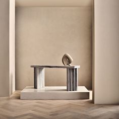 a sculpture sitting on top of a wooden floor next to a white table and chair