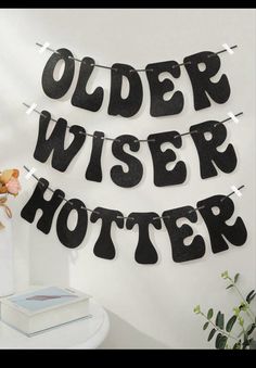 a black and white banner that says older wiser potter on it next to a potted plant