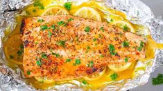 a piece of fish on foil with lemons and parsley