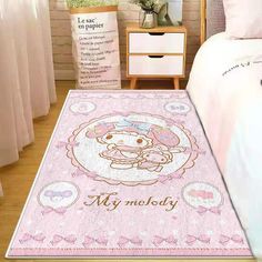 a hello kitty rug is on the floor next to a bed with pink sheets and pillows