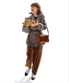 a woman in brown pants holding a tray of food and looking at the camera with an excited look on her face