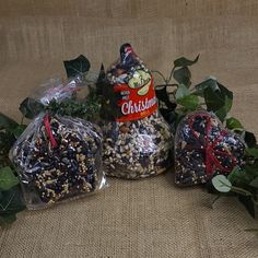 three bags of bird seed sitting on top of a table next to plants and leaves