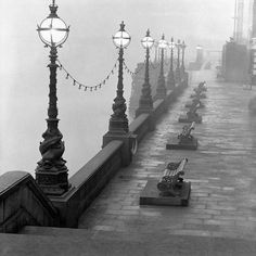 the benches are lined up along the water's edge in this black and white photo