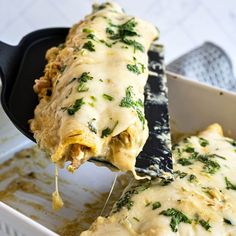 a spatula scooping some food out of a casserole dish with cheese and spinach